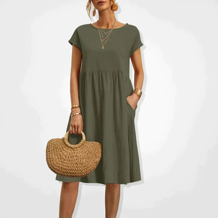 Model trägt knielanges Elodie Leinen Sommerkleid, entspannt & luftig. Perfekt für Damen Freizeitlook an warmen Tagen.