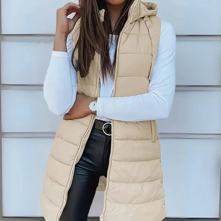 Stylische lange Kapuzen-Pufferweste für Damen, warm und bequem, perfekt für modische Layering-Outfits im Herbst/Frühling.