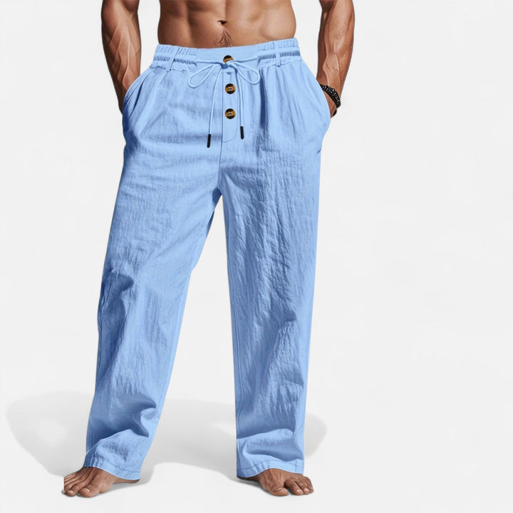 Mann trägt weite Herrenhose Leinen-Optik mit Kordelzug; atmungsaktive Sommerhose in entspannter Passform.