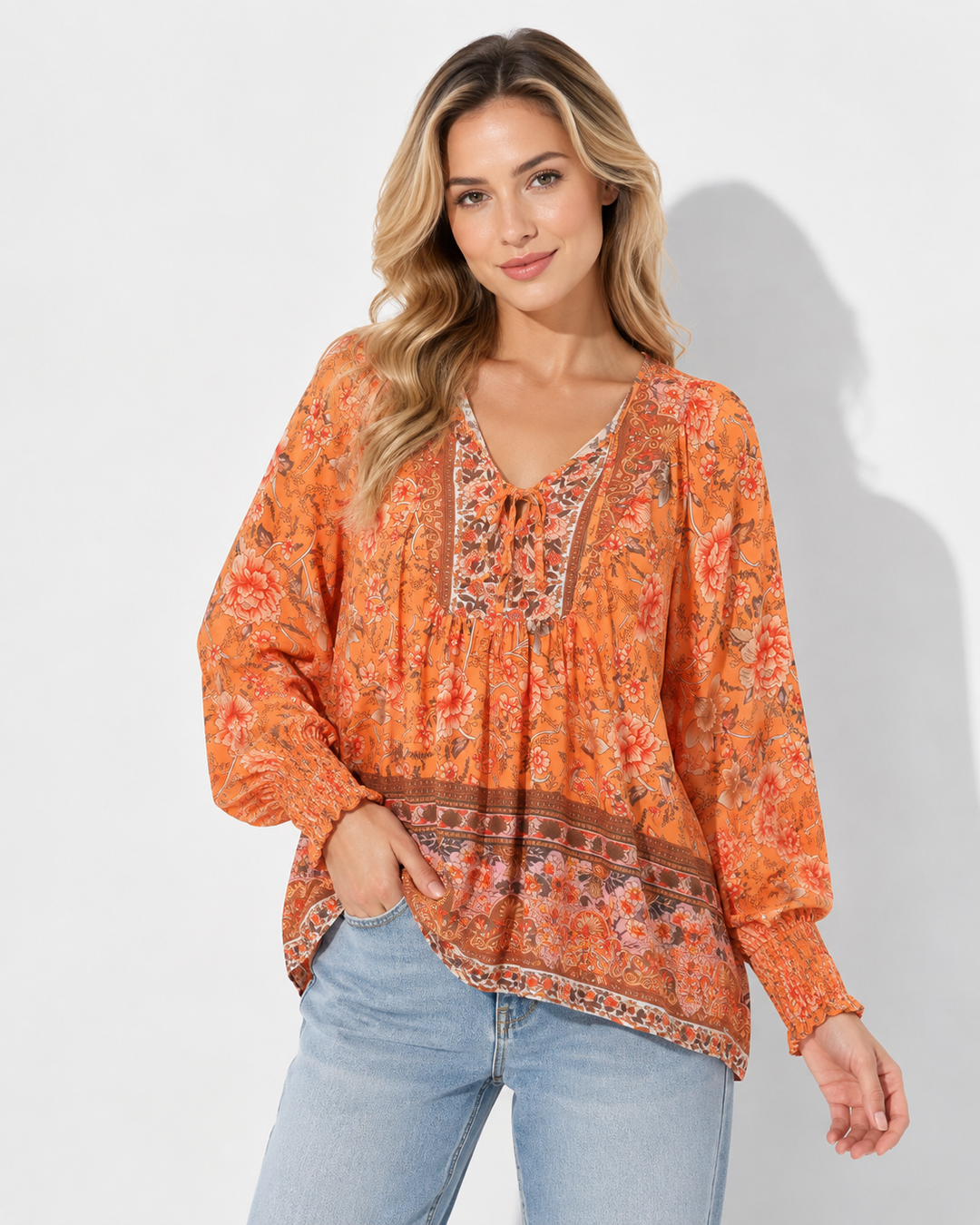 Modische Dame trägt bedrucktes Langarmshirt mit V-Ausschnitt & Krawattendetail. Elegantes Freizeit Oberteil.