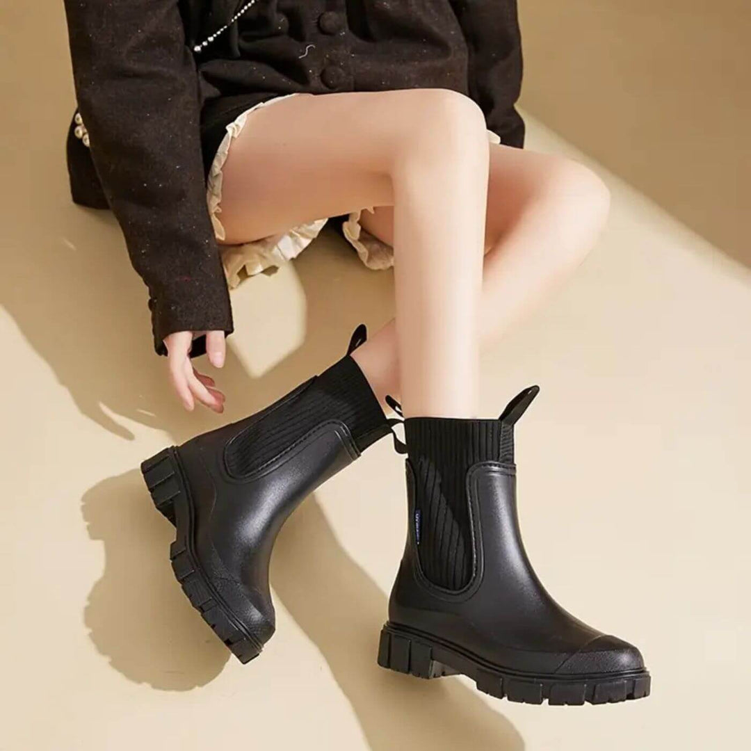 Damen-Regenstiefel beim Spaziergang im Regen. Wasserdichte Gummistiefel bieten sicheren Halt & Komfort bei Nässe.