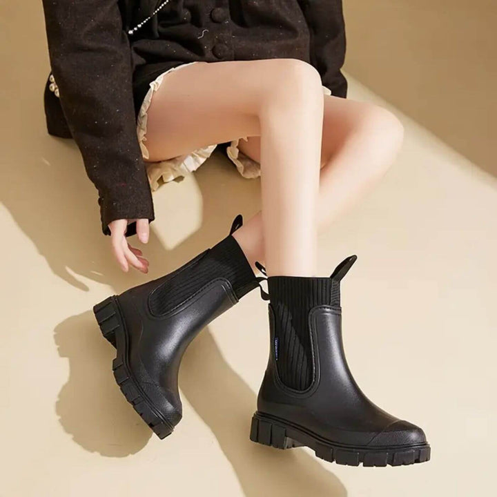 Damen-Regenstiefel beim Spaziergang im Regen. Wasserdichte Gummistiefel bieten sicheren Halt & Komfort bei Nässe.