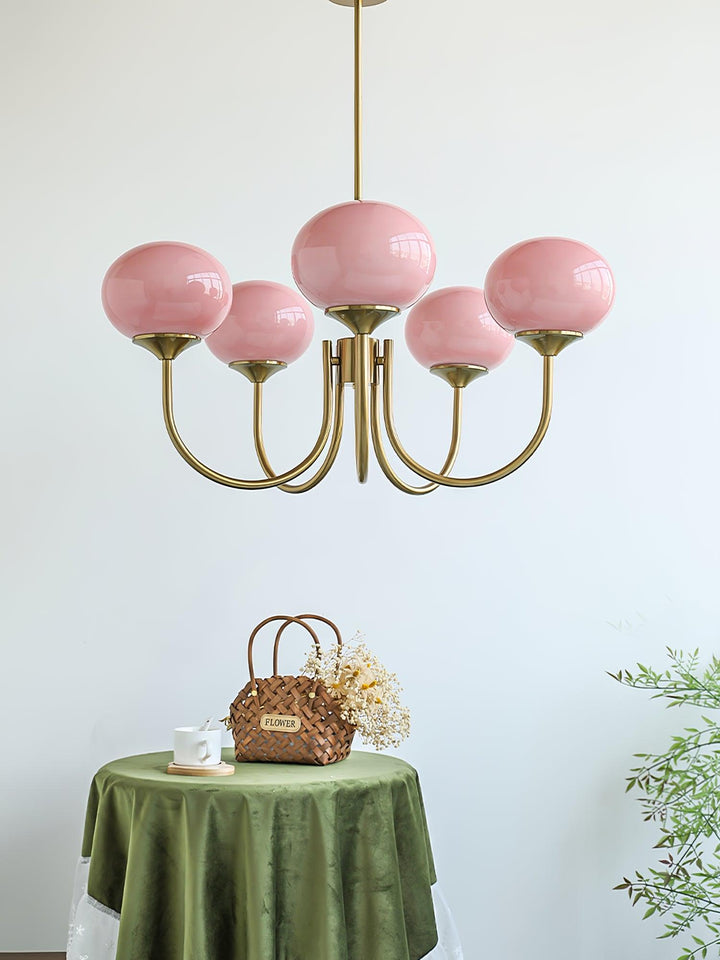 Warmer Gold-Kronleuchter mit runden Glas-Lampenschirmen; gemütliche Innenraumbeleuchtung.