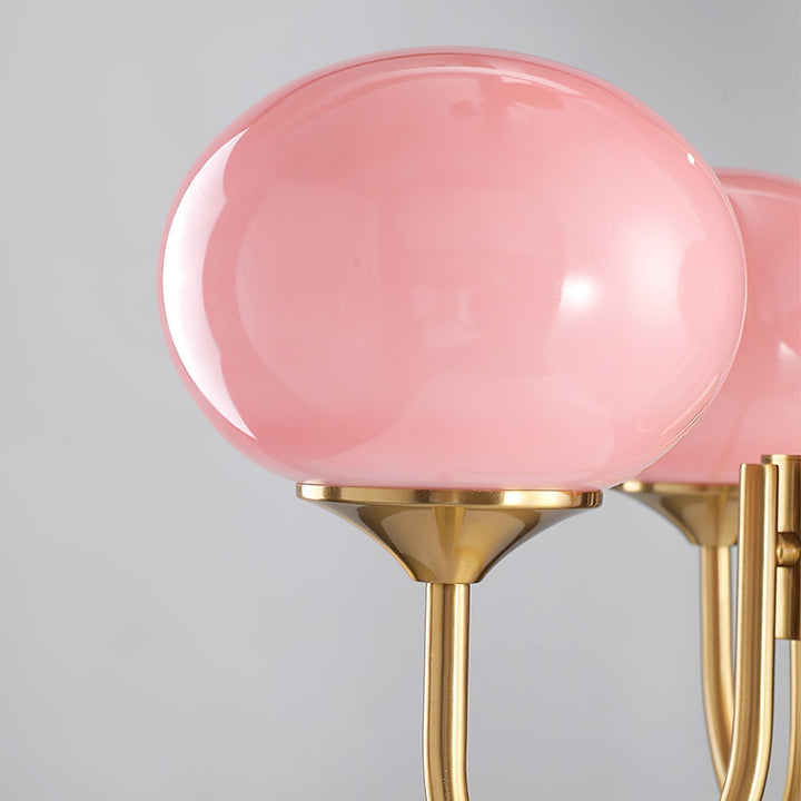 Moderner Roségold-Kronleuchter mit runden Glas-Lampenschirmen; warme Wohnzimmerbeleuchtung.