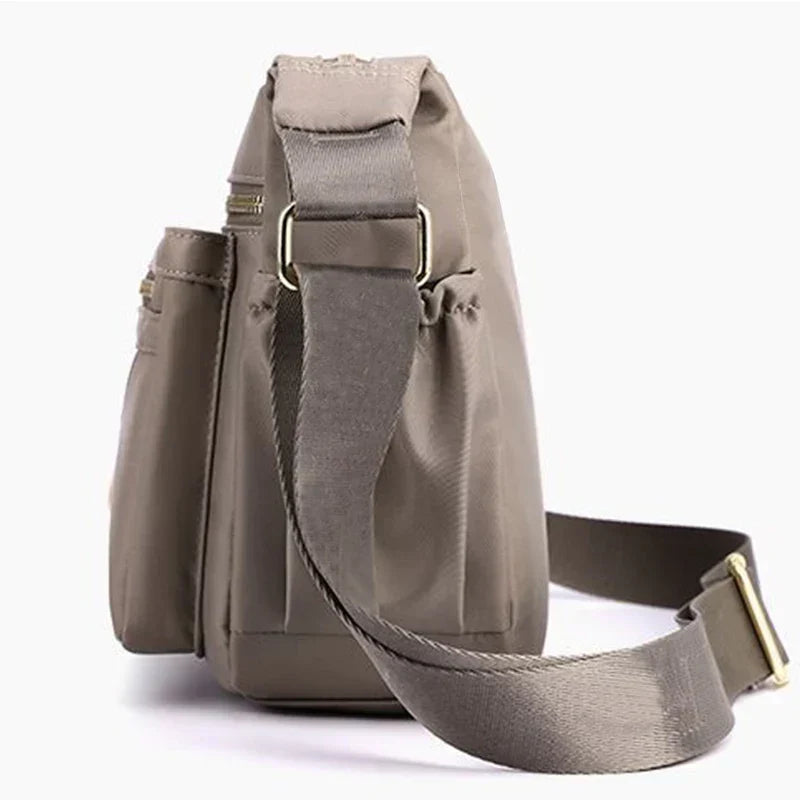 Seitenansicht der khaki Unisex Messenger-Bag. Geräumige Nylon Umhängetasche für Reiseutensilien.