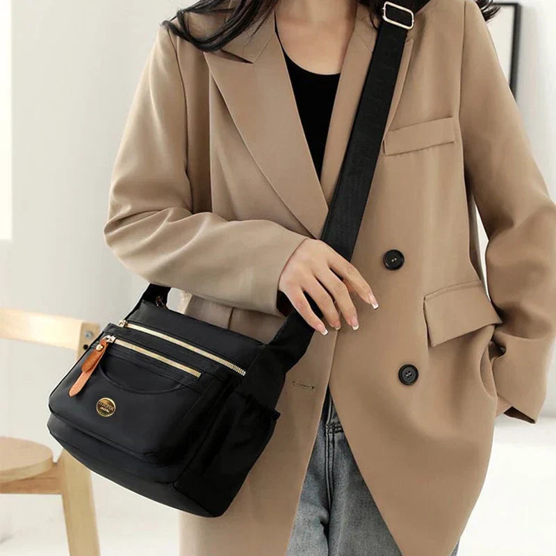 Junge Person trägt rosa Unisex Crossbody-Tasche. Trendige Nylon Alltagstasche bequem über der Schulter.