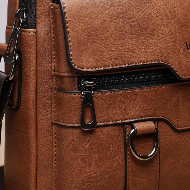 Nahaufnahme der hochwertigen PU-Leder-Textur einer kompakten Unisex Messenger-Tasche in Braun.