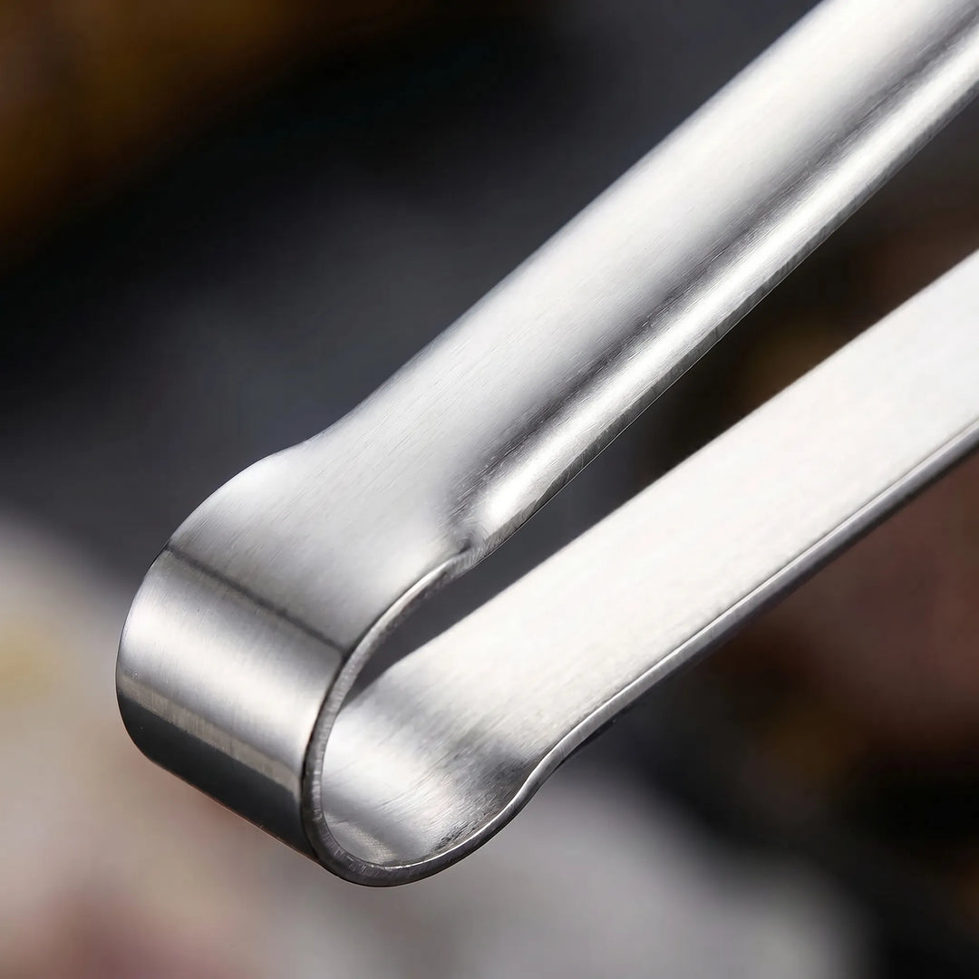 Robuste Grillzange aus Edelstahl, lange Form für sicheres Wenden am Barbecue.