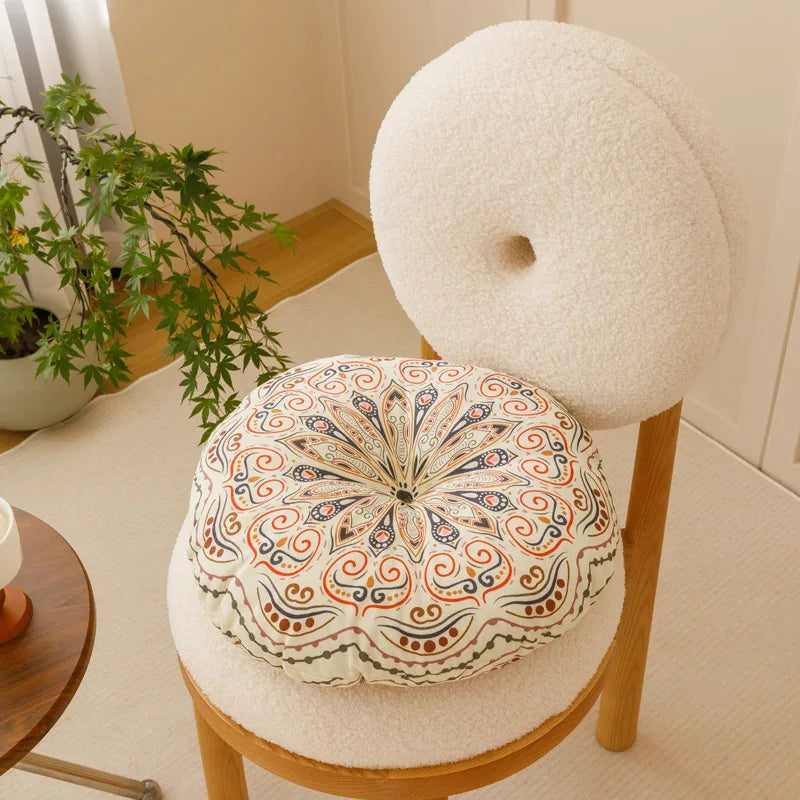 Rundes Sitzkissen mit Boho-Flair, ideal für entspannte Abende oder gemütliche Lesestunden.