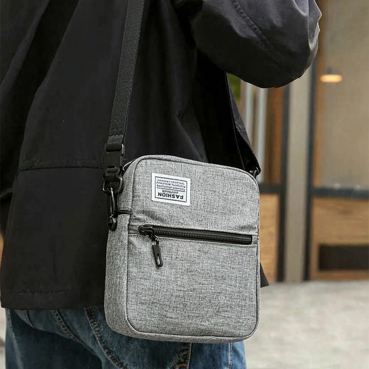 Herren Umhängetasche kompakt, quadratisch, stilvoll in Grau. Perfekt als Crossbody Bag für den Alltag oder Reisen.