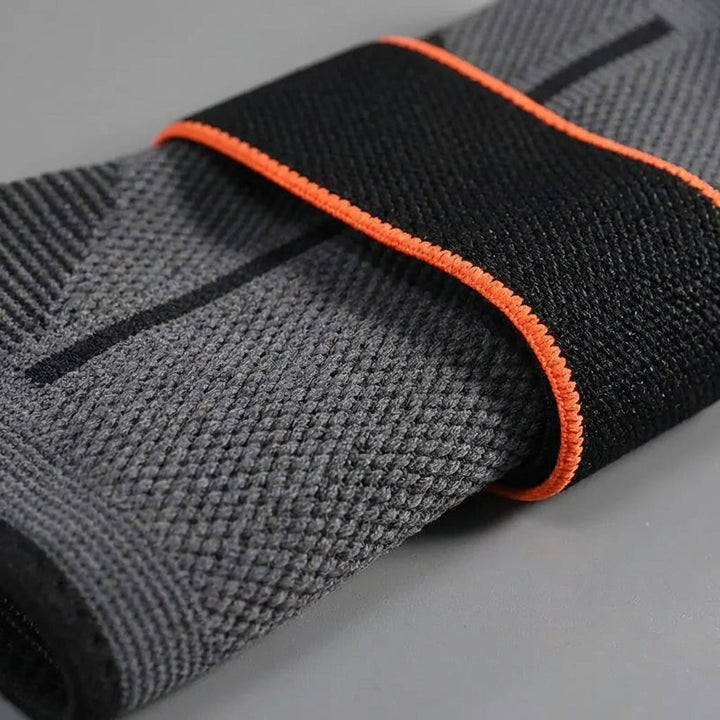 Ergonomische Kompressions-Knöchelstütze, schwarz, mit verstellbaren Riemen für optimale Gelenkstabilisierung.