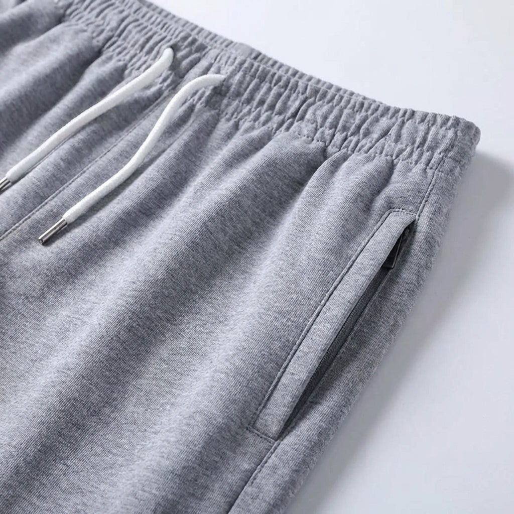 Detailansicht der Herren Shorts: Elastikbund, Kordelzug & seitliche Reißverschlusstasche.