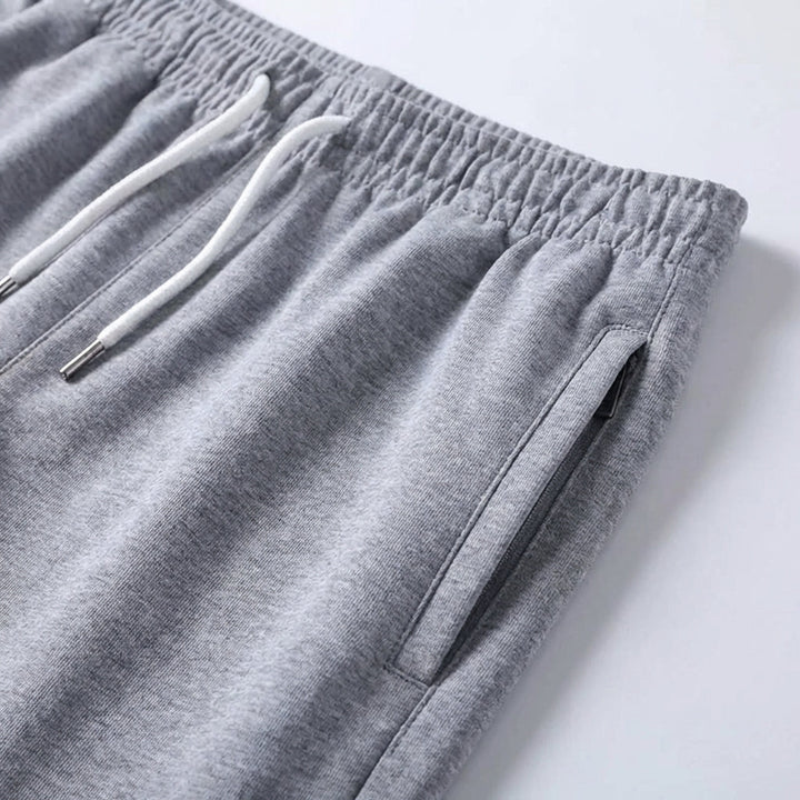 Detailansicht der Herren Shorts: Elastikbund, Kordelzug & seitliche Reißverschlusstasche.