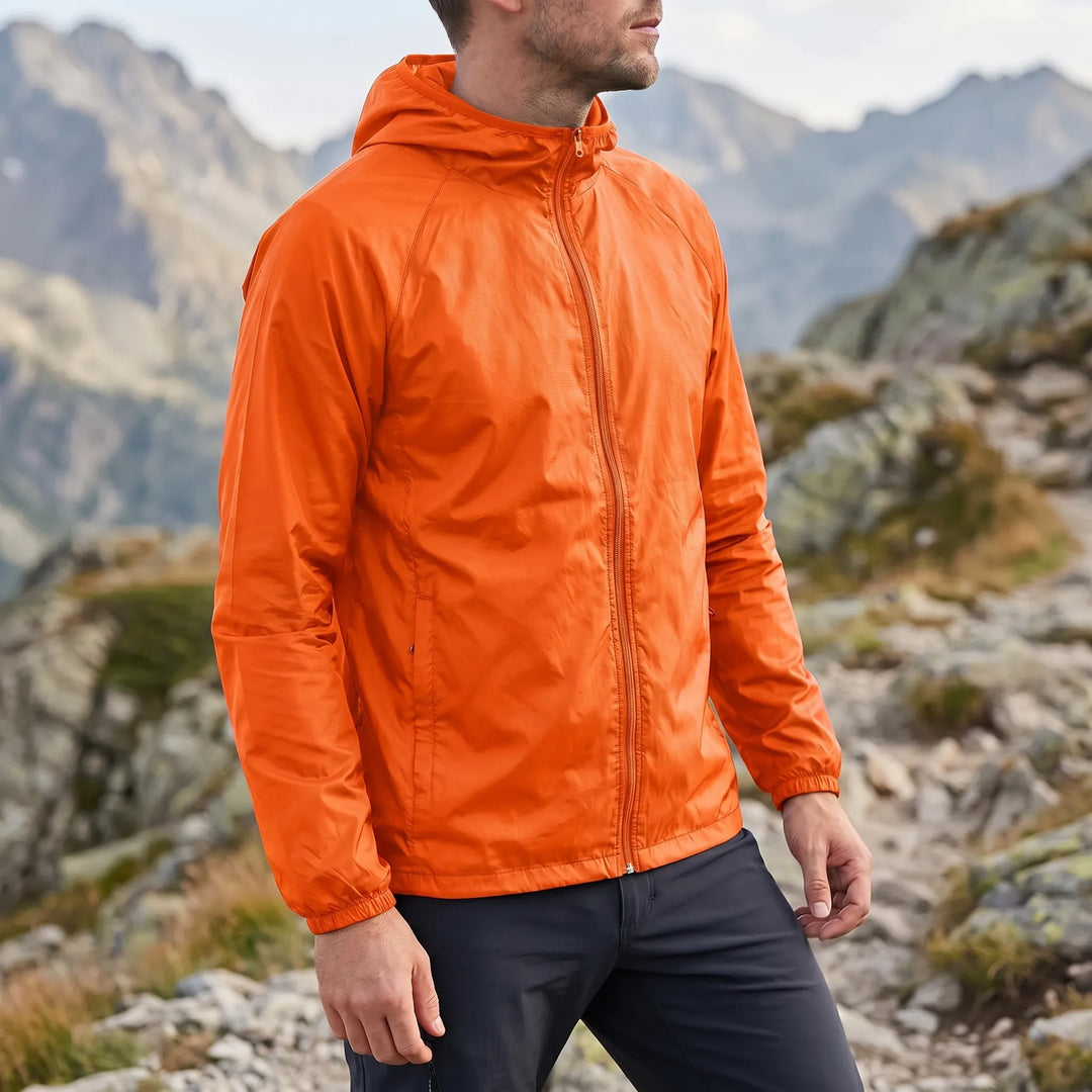 Frau trägt leichte unisex Kapuzen-Windbreaker beim Spaziergang am Meer, schützt vor Wind.