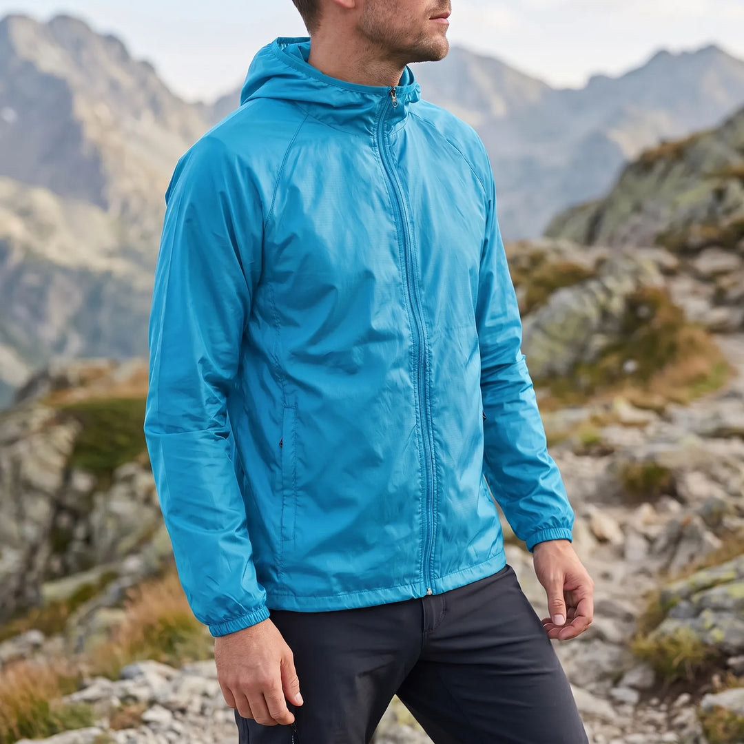 Unisex Windjacke im Einsatz, Person wandert auf einem Bergpfad, windgeschützt & komfortabel.