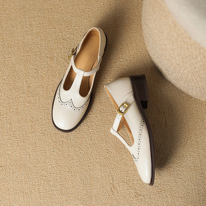 Damen Pumps mit detailliertem Broguing, stabiler Blockabsatz, klassischer Mary Jane Look.