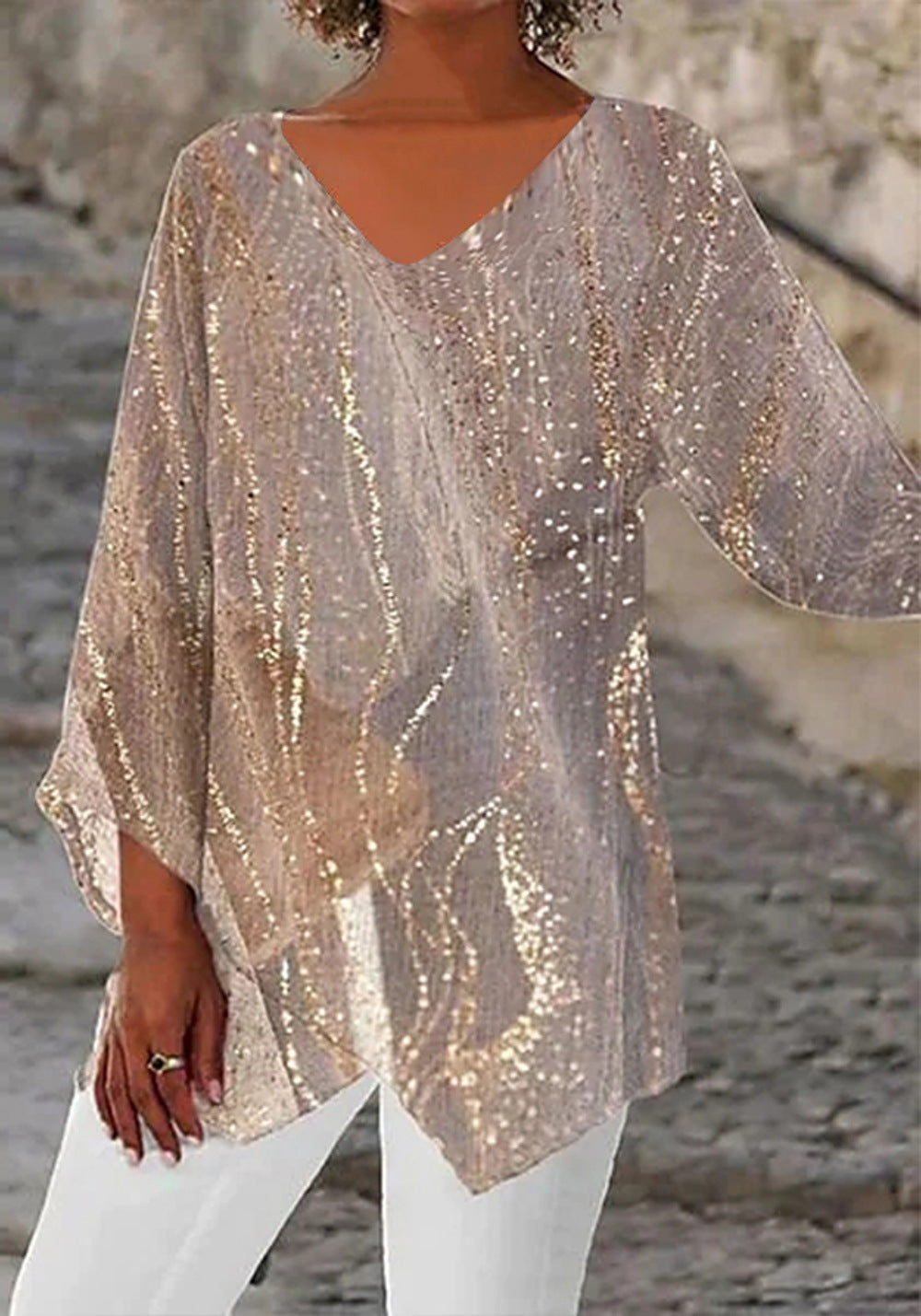 Model trägt türkise Glitzer Tunika Bluse mit Dreiviertelarm. Elegant, fließend und ideal für Abendmode.