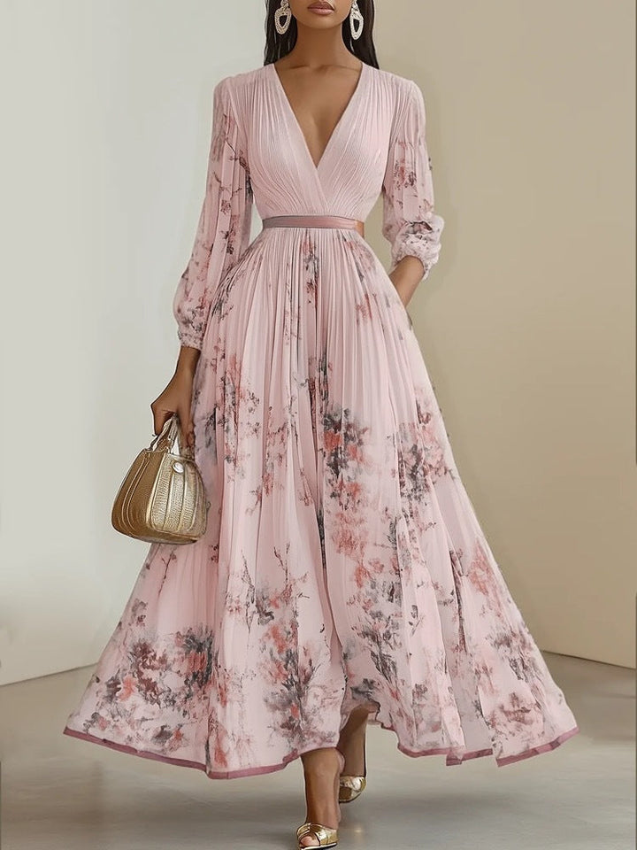 Model in elegantem Damen Maxikleid mit Blumenmuster, V-Ausschnitt und Puffärmeln. Ideal für sommerliche Anlässe.