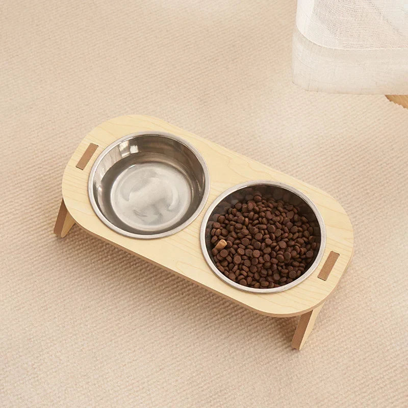 Eine Katze trinkt aus dem schicken Holz-Doppelnapf mit Edelstahl, ideal als Futterstation für kleine Hunde.