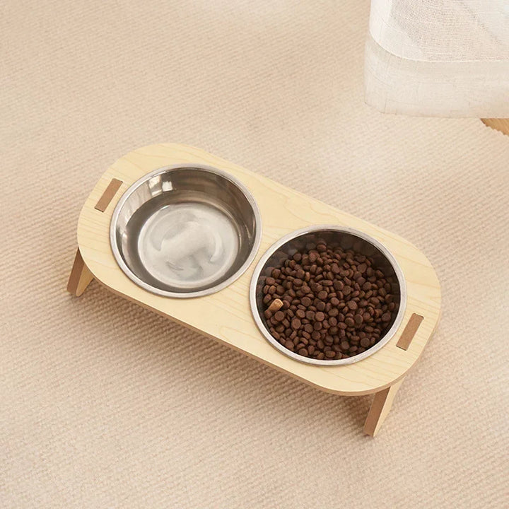 Eine Katze trinkt aus dem schicken Holz-Doppelnapf mit Edelstahl, ideal als Futterstation für kleine Hunde.