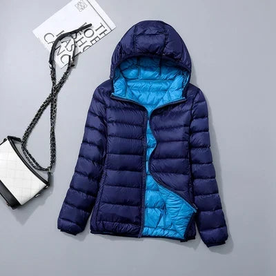 Feminine, leichte Windjacke mit Kapuze, wendbar, für stilvollen Outdoor-Auftritt im Frühling.