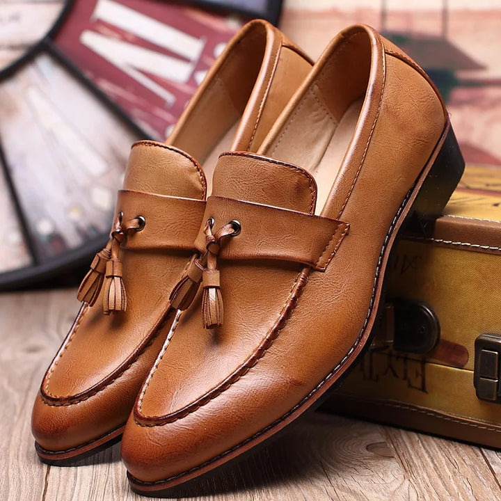 Nahaufnahme der glänzenden Doppelquasten an eleganten Herren Loafern, stilvolle Details für Herrenschuhe.