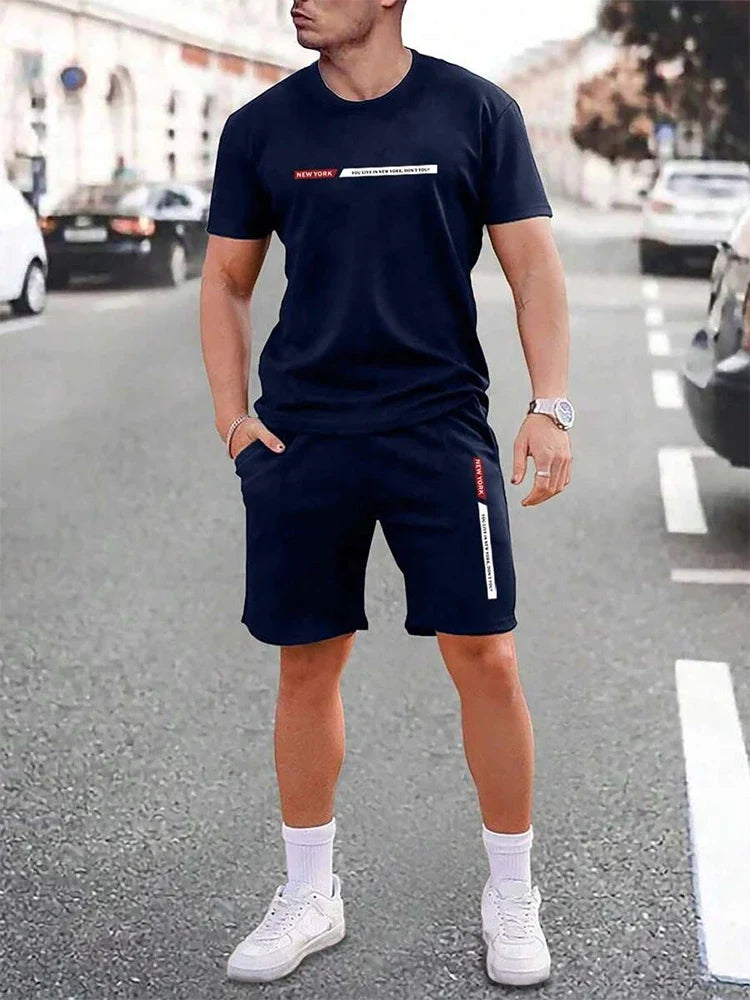 Model trägt lässiges Herren T-Shirt-Set mit Shorts. Sportlicher Zweiteiler für entspannte Sommertage, Alltag & Urlaub.