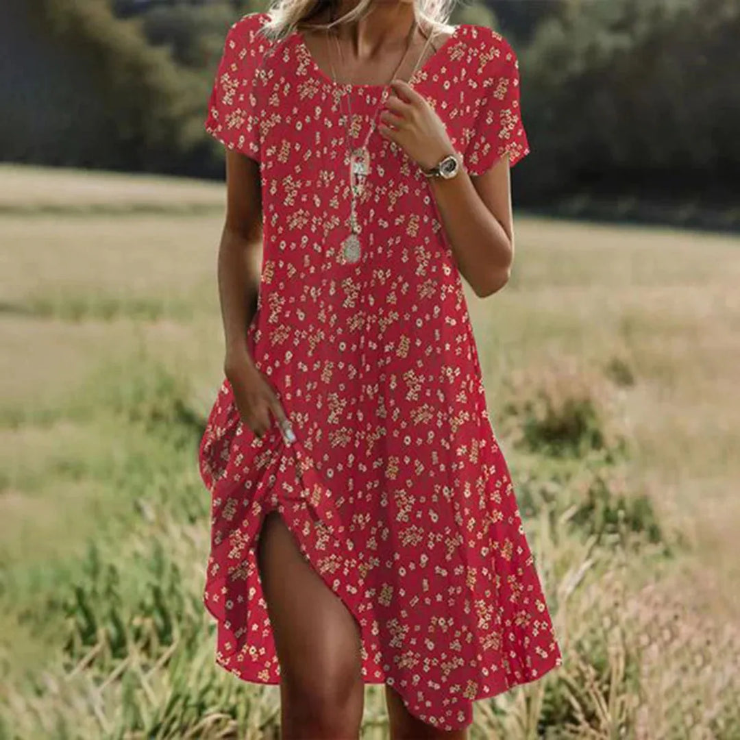 Frau trägt grünes, asymmetrisches Boho-Sommerkleid mit Kurzarm, ideal als Strand- oder Urlaubskleid.