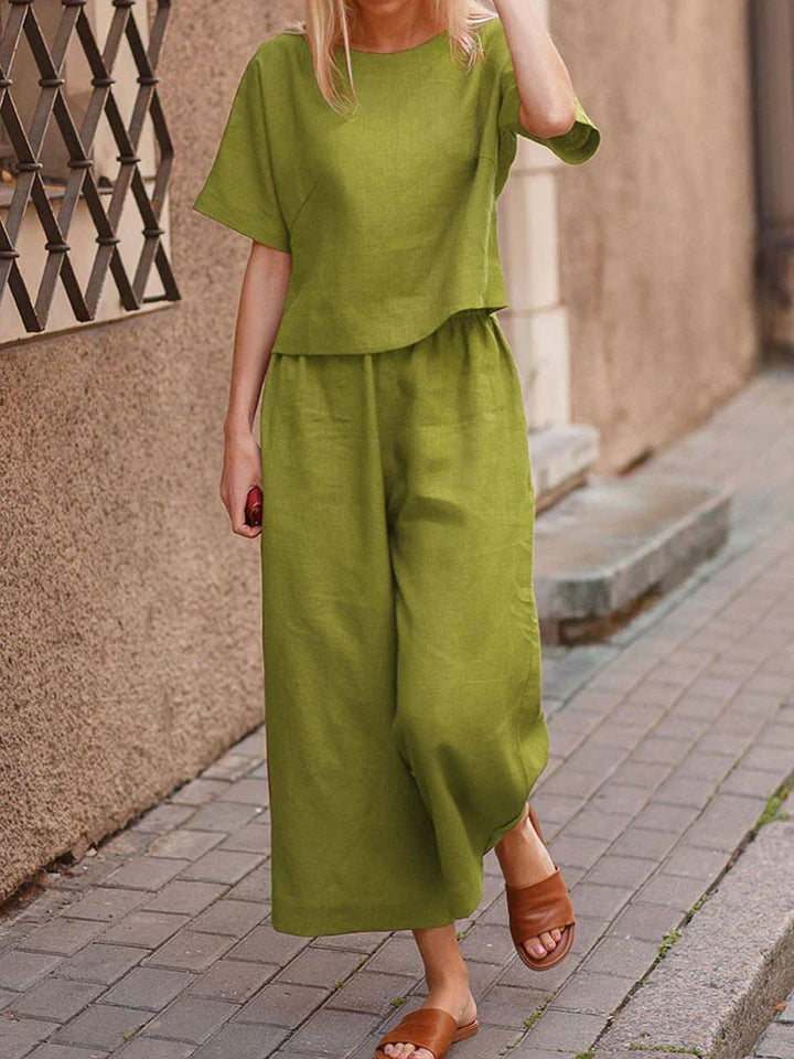 Frau trägt entspanntes Damen Sommer Zweiteiler Set mit weitem Hosenbein & Kurzarm T-Shirt. Perfektes Sommer Outfit.