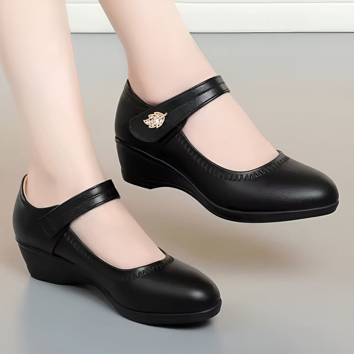Stilvolle Damen Keilabsatzschuhe mit sicherem Riemenverschluss. Rutschfest und bequem für lange Tage.