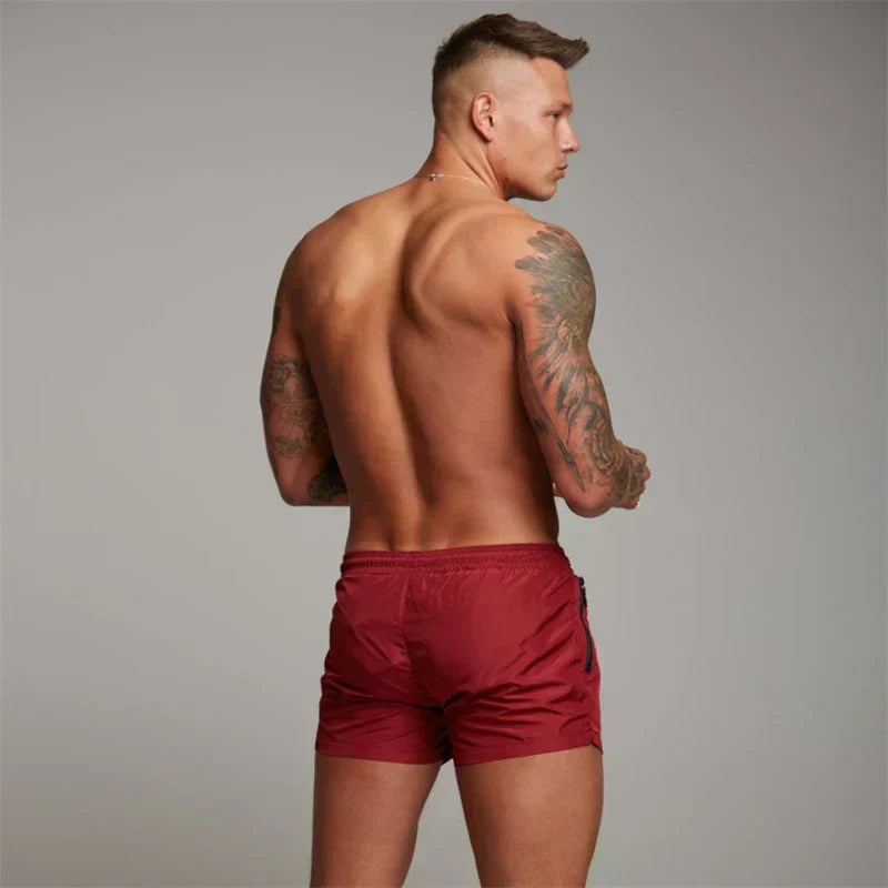Schwarze Herren Badeshorts, sportlich mit praktischen Reißverschlusstaschen, ideal für den Sommerurlaub.