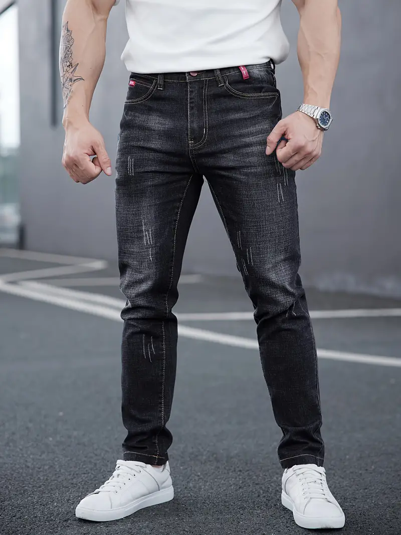 Mann trägt schmale, schwarze Herren Tapered Jeans. Komfortable Slim Fit Herrenhose für stilvolle Looks.