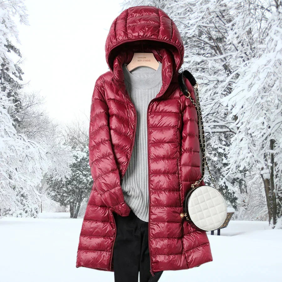 Frau trägt ultraleichte, wasserabweisende Damen-Daunenjacke mit Kapuze. Ideal für Outdoor & kalte Tage.