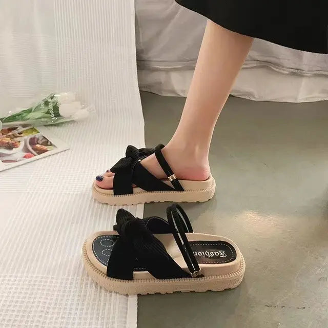 Frau trägt komfortable Espadrille-Sandalen mit Wickelbändern am Strand; ideal für Sommerurlaub.