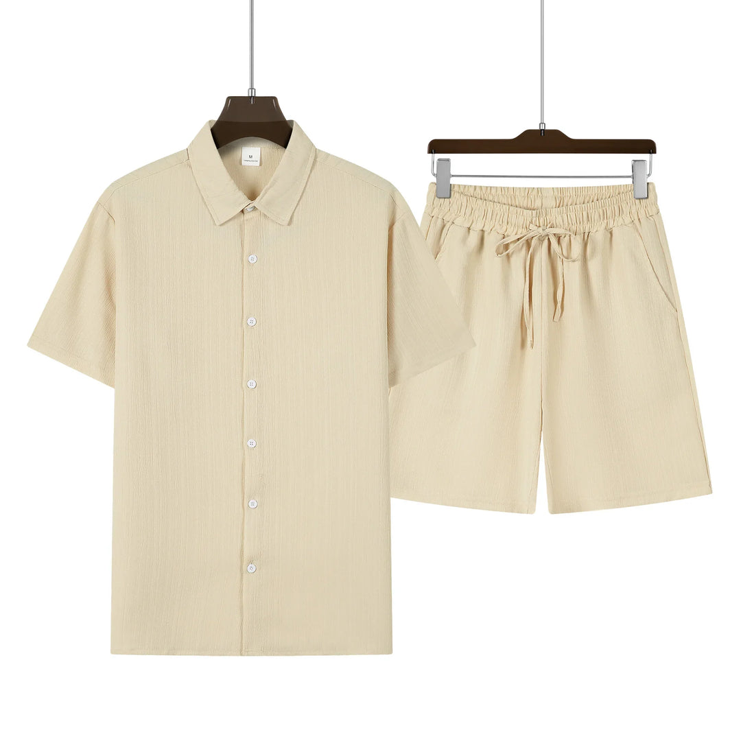 Mann sitzt entspannt im Herren Sommer Set. Stilvolles Kurzarmhemd & Shorts für entspannte Tage.