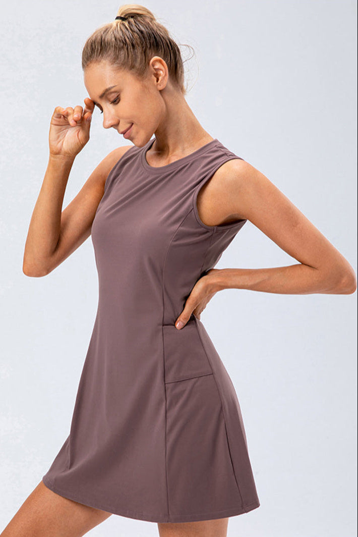 Schwarzes Performance Tennis Kleid Damen, ärmellos, mit integrierten Shorts und funktionellen Taschen.