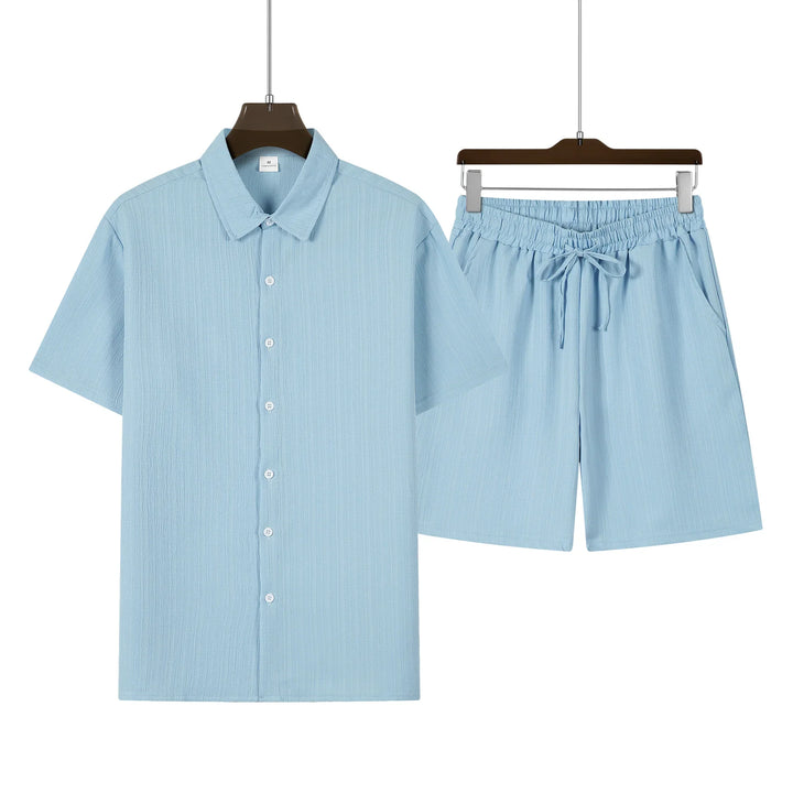 Mann posiert im kompletten Herren Kurzarmhemd & Shorts Set. Perfekte, bequeme Sommerkleidung.