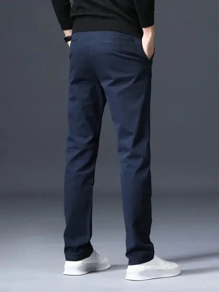 Model trägt klassische Herrenhose gerade geschnitten, betont die schmeichelhafte Passform und Eleganz.
