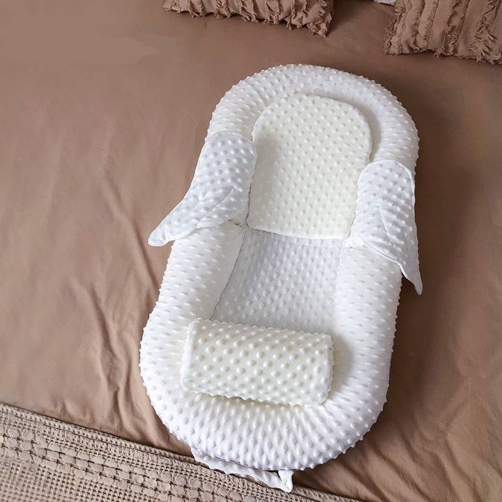 Modernes Babynest in Grau, ergonomisch geformt, mit atmungsaktiver Liegefläche für ganzjährigen Komfort.