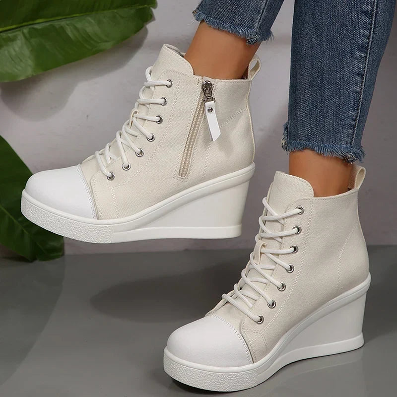 Vordere Ansicht der schwarzen Damen Keil-Sneaker, betont die stilvolle Schnürung.