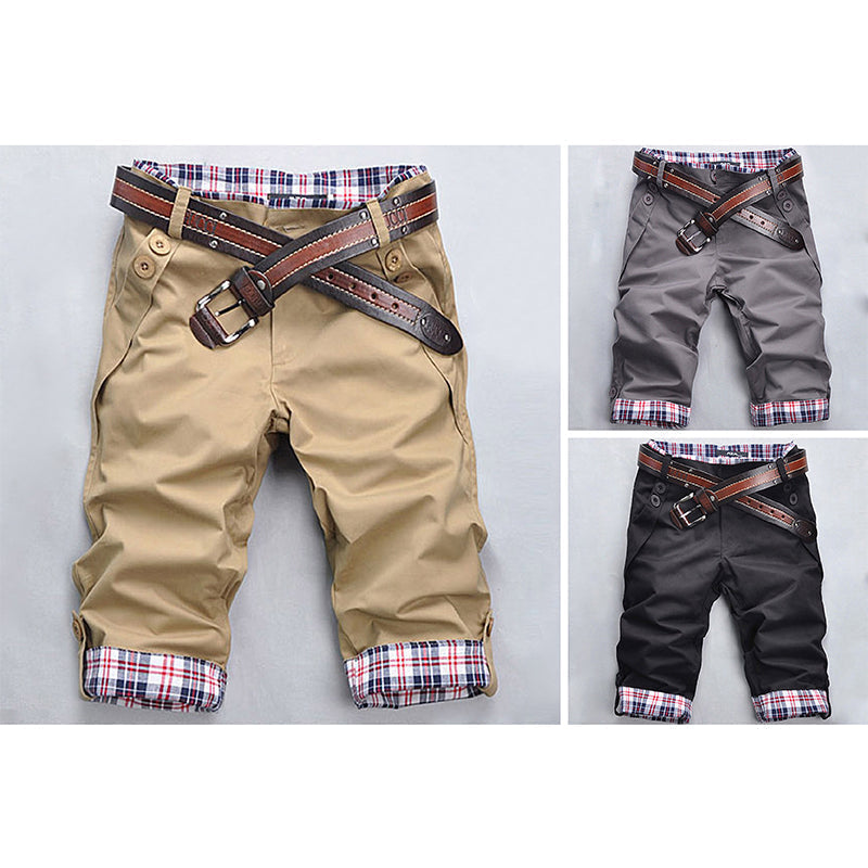 Mann trägt modische Karo-Shorts am Strand, bereit für Sommer & Wasseraktivitäten, casual Look.