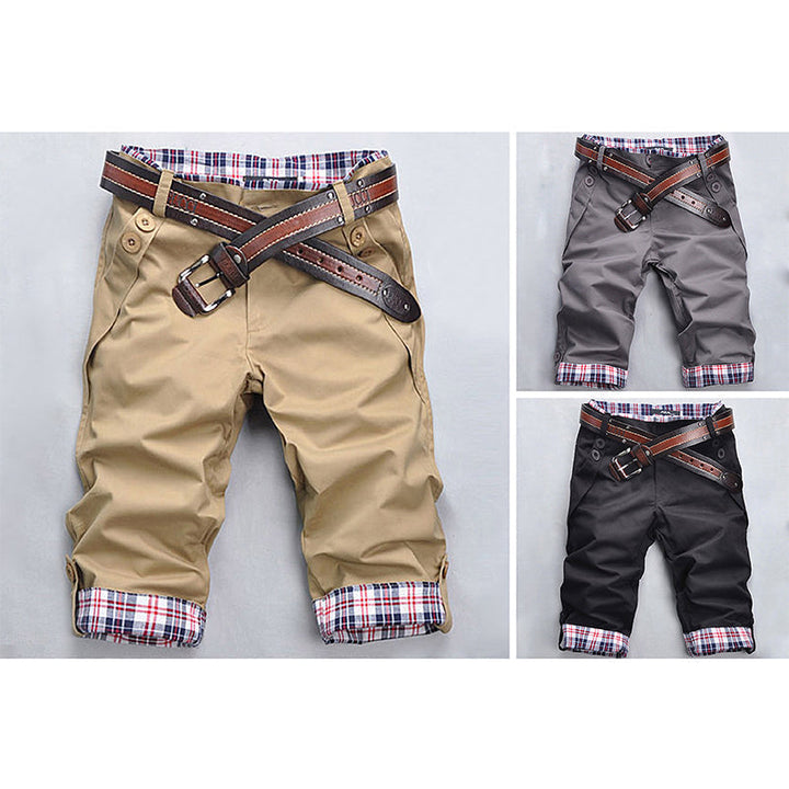 Mann trägt modische Karo-Shorts am Strand, bereit für Sommer & Wasseraktivitäten, casual Look.