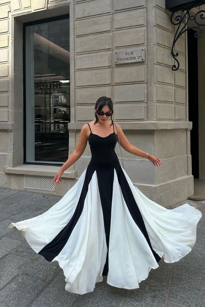 Elegantes schwarzes Maxikleid für Hochzeitsgäste mit Spaghettiträgern und Kontrastdesign, festlich.