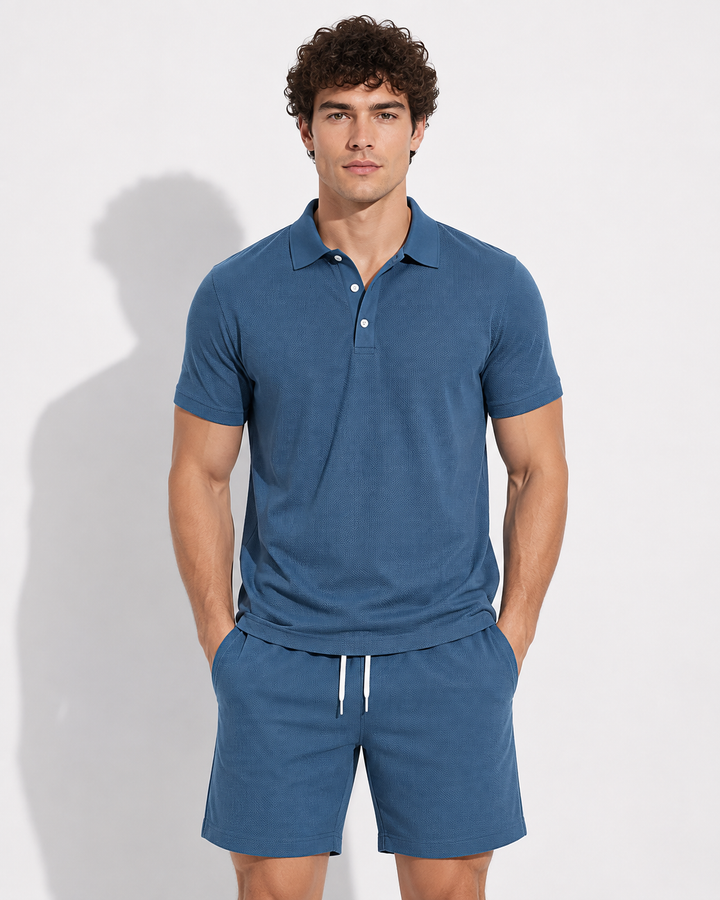 Modernes Herren Reiseoutfit: Unifarbenes Polohemd & passende Shorts. Bequem und elegant für den Sommer.
