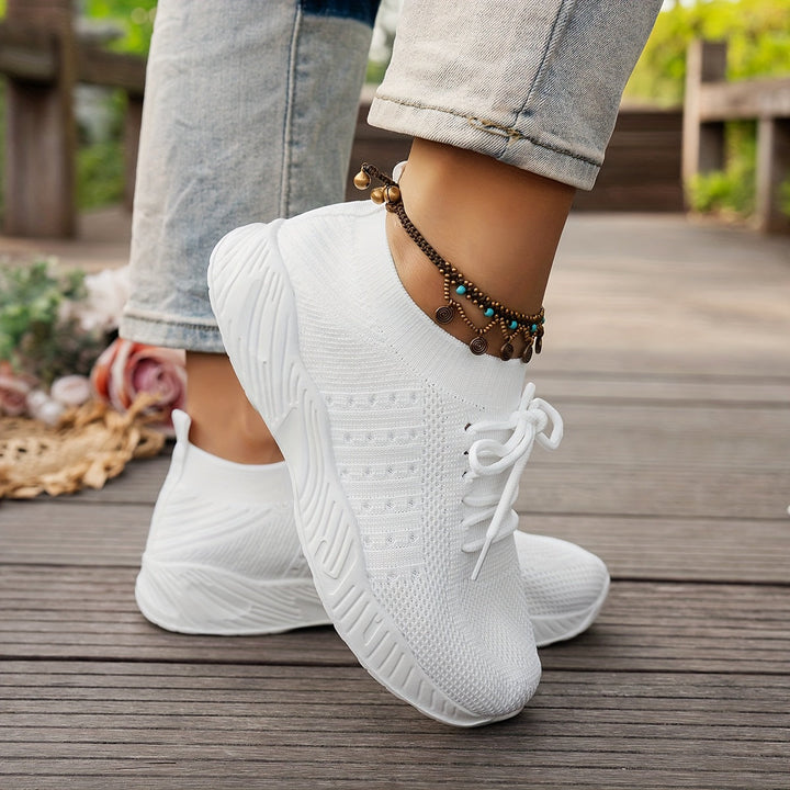 Ein Paar weiße Damenschuhe. Leichte Freizeitschuhe, die Komfort und Stil für jeden Tag vereinen. Alltagsschuhe.