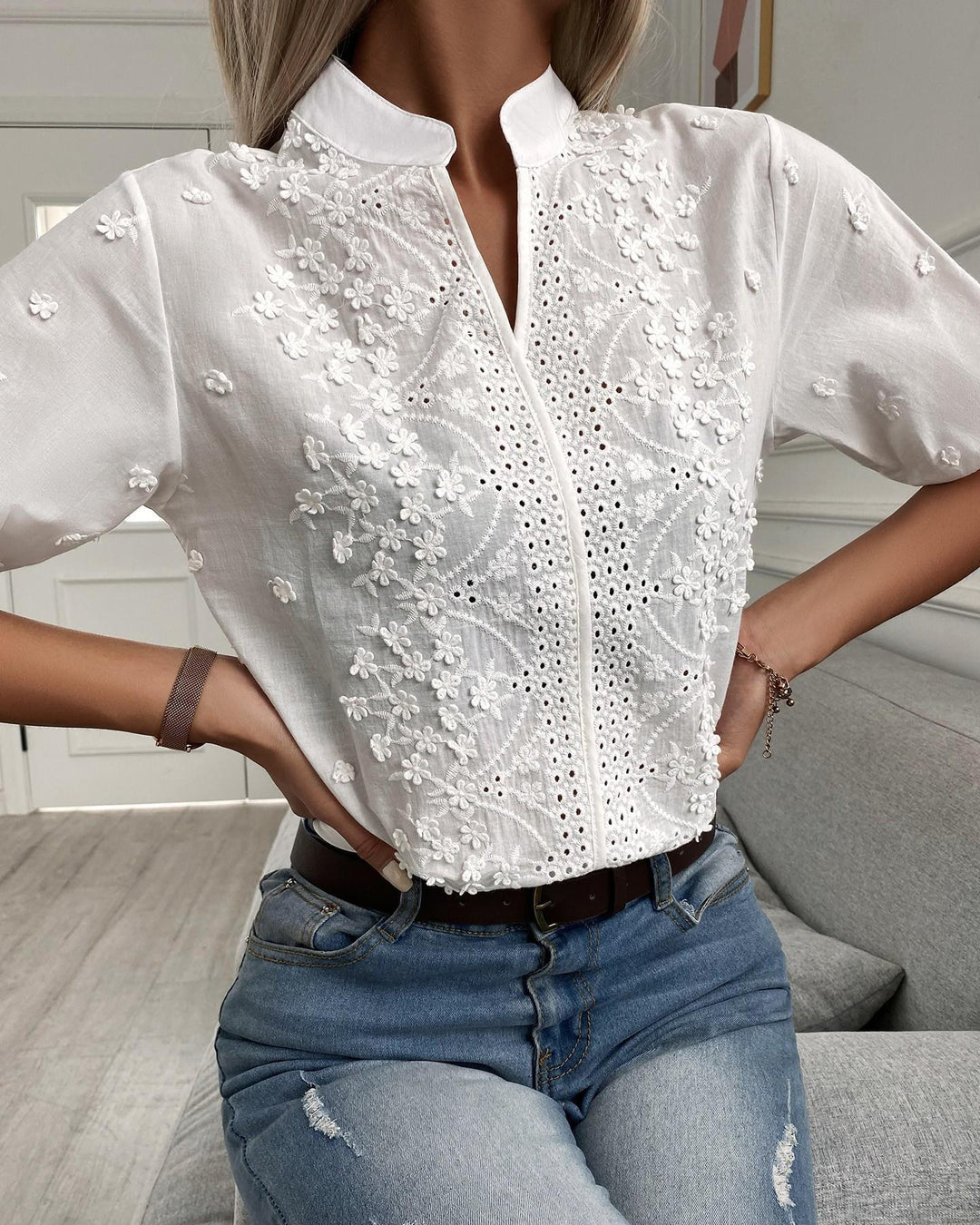 Schicke weiße Damenbluse mit filigraner Zierstickerei und V-Ausschnitt, Kurzarm, perfekt für elegante Sommer-Outfits.