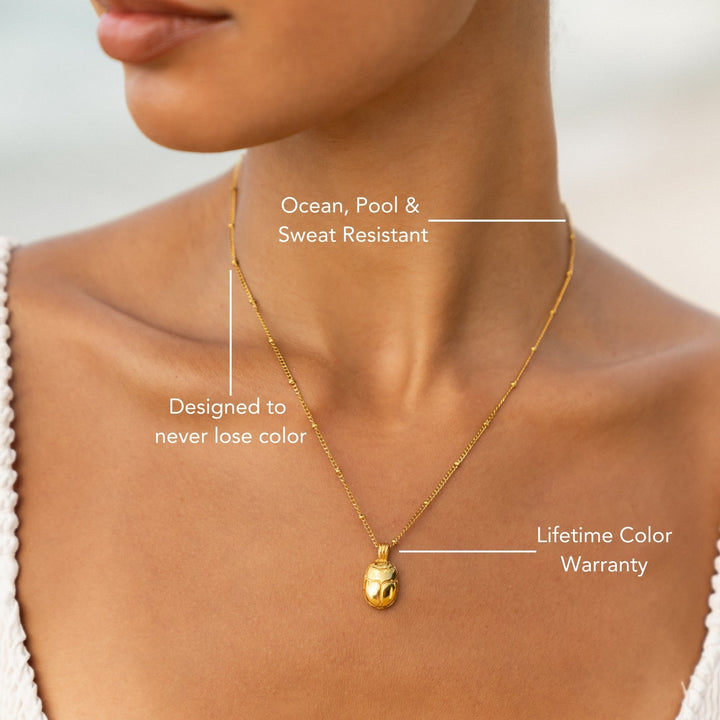 Minimalistische goldene Skarabäus Halskette mit wasserfestem Anhänger und strahlendem grünem Zirkonia.