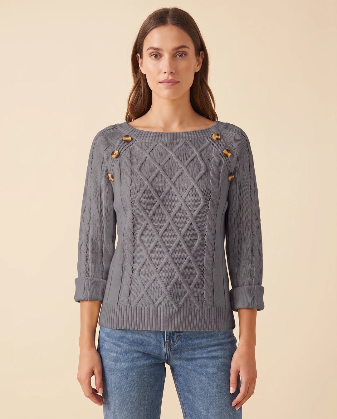Frau trägt eleganten Damen Zopfstrickpullover mit Schulterknöpfen, kombiniert für Komfort und Mode.