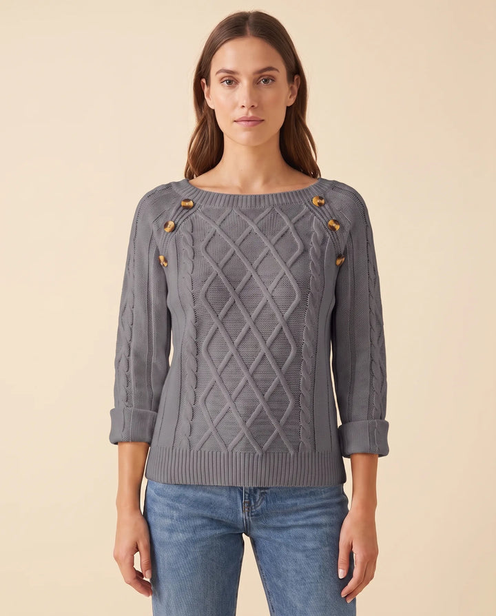 Frau trägt eleganten Damen Zopfstrickpullover mit Schulterknöpfen, kombiniert für Komfort und Mode.
