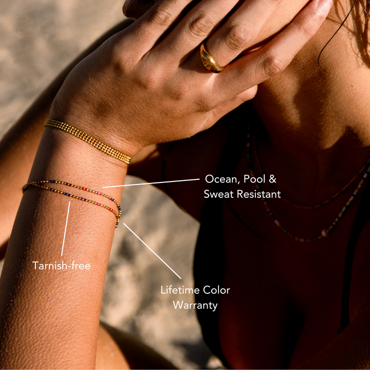 Nahaufnahme: Goldenes Gliederarmband für Damen, glänzender Edelstahl, verstellbares Design, elegant.